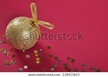 Christmas gold glitter bauble with ribbon and bow  over red background.