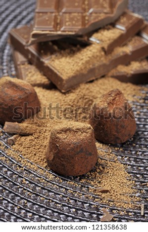 chocolate truffles with cocoa powder and chocolate slices on a dark background
