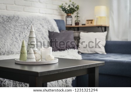 Christmas decorations with candle on coffee table in living room near couch closeup