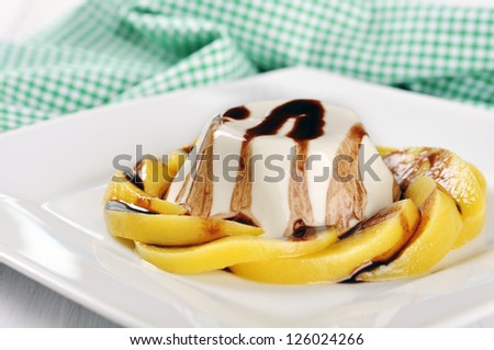 Italian dessert Panna cotta with peach and chocolate sauce on the plate