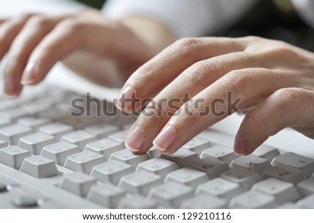 Close-up of typing female hands on white keyboard
