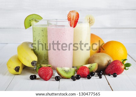 Fruit Smoothies With Black Currant, Strawberry, Kiwi, Orange And Banana On White Wooden Background