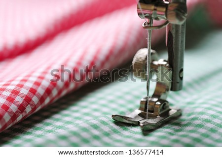 Part of sewing machine and checkered fabric closeup