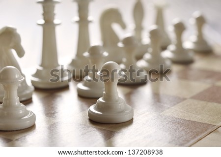 chess pieces on a wooden desk closeup