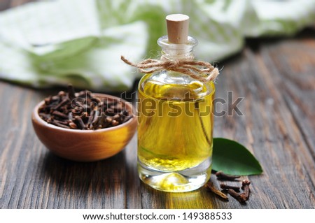 Oil of cloves in a glass bottle over wooden background