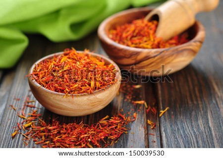 Saffron in wooden bowl on wooden background