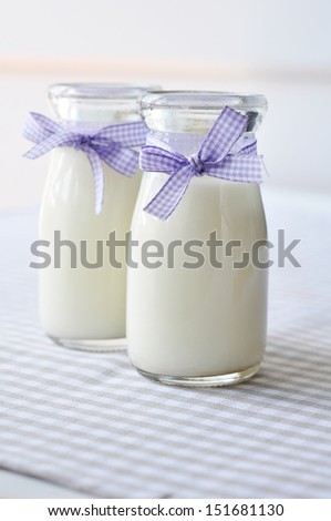 Milk in glass jars on a  checkered table