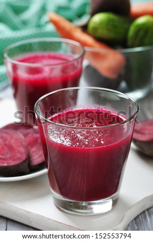 Beetroot juice in glass on  wooden cutting board