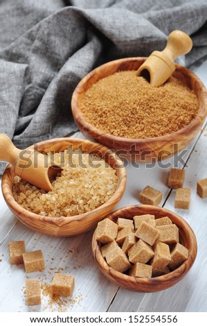 brown and white sugar in wooden bowls closeup