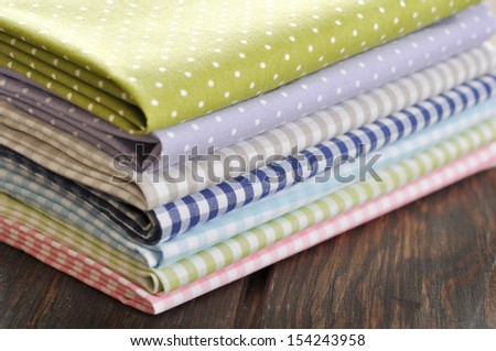 heap of  fabrics on wooden table closeup