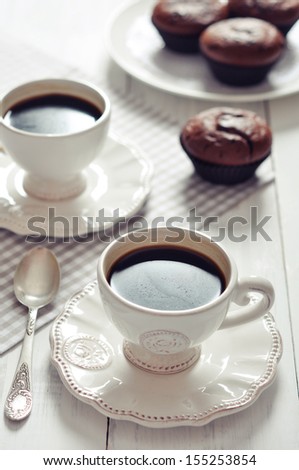 Cup of coffee with spoon and chocolate  muffins