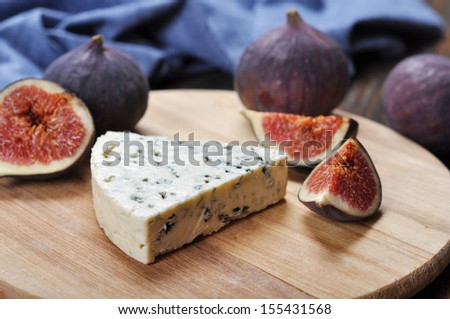 blue cheese and  fruit figs on a wooden cutting board