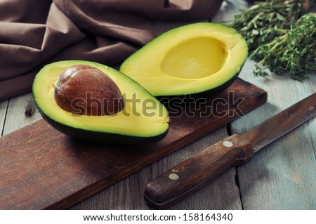 Fresh Avocado On Cutting Board Over Wooden Background