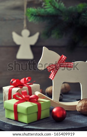Christmas decorations with gift boxes and horse toy on wooden background