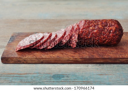 Sliced salami  on wooden cutting board closeup