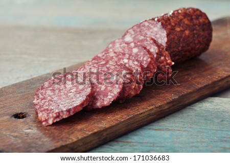 Sliced salami  on wooden cutting board closeup
