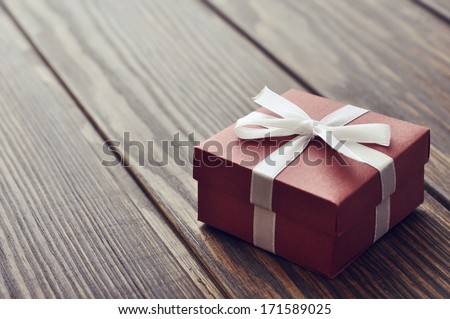 Elegant gift box on a wooden background closeup
