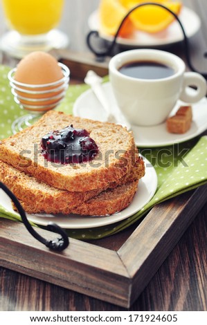 Breakfast with toast, fruit jam, and coffee on tray