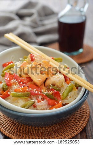 Rice noodles with chicken and vegetables in bowl closeup