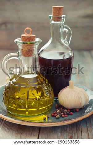 Olive oil and wine vinegar in bottles on wooden background