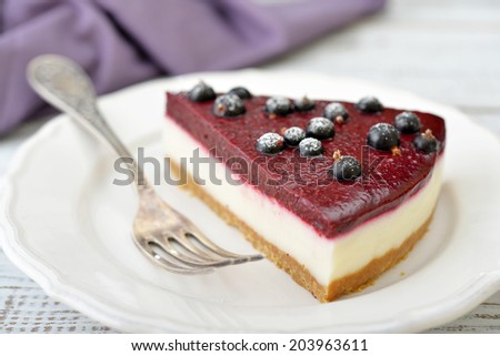 Black currant cheesecake with fresh berries on plate closeup