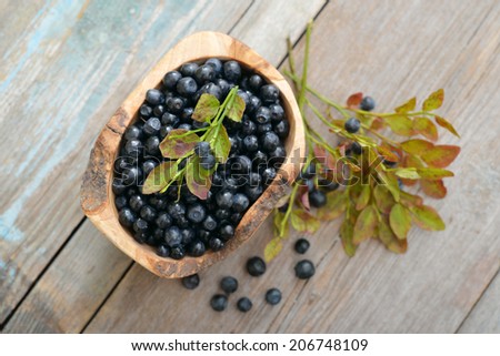 Fresh blueberry in wooden bowl on wooden background