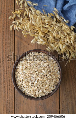 Oatflakes in a bowl on wooden background
