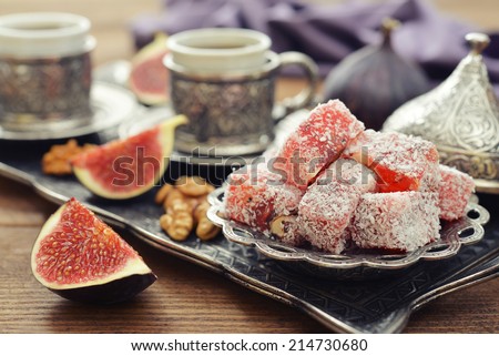 Cup of coffee with turkish delight  and metal oriental tray on wooden background