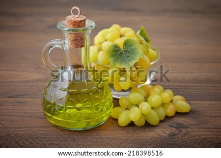 Grape seed oil in a glass jar on wooden background
