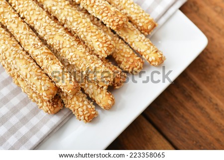 Bread sticks with sesame seeds on plate closeup