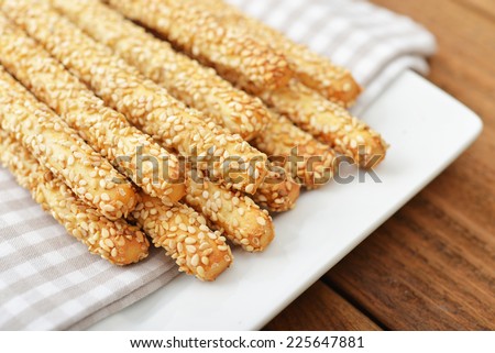 Bread sticks with sesame seeds on plate closeup
