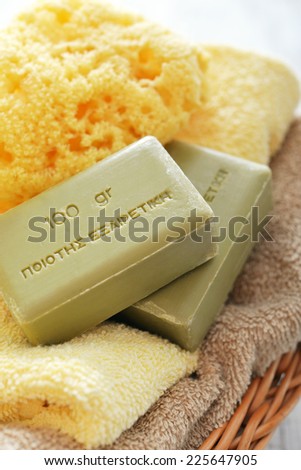 Greek olive soap with bath towels  in basket closeup. The words on soap translates as \