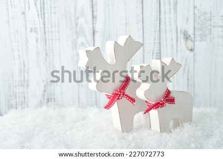 Christmas decoration in form of elks on light wooden background