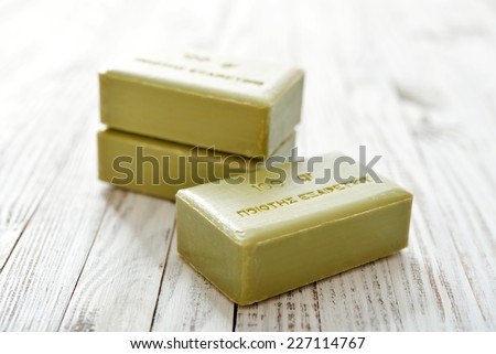Greek olive soap on wooden background closeup. The words on soap translates as \