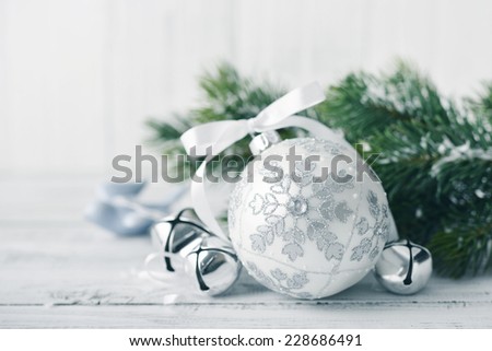 White christmas balls and fir branches with decorations on light background