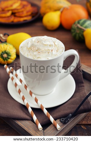 Pumpkin spice latte with whipped cream, cinnamon and decorative pumpkins