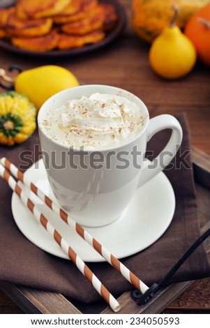 Pumpkin spice latte with whipped cream, cinnamon and decorative pumpkins