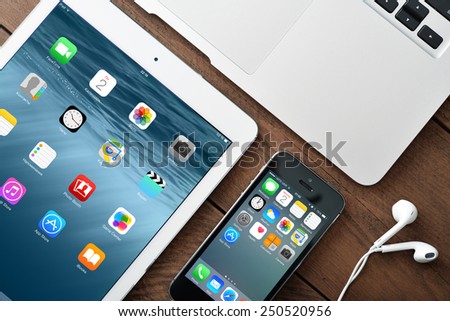 KIEV, UKRAINE - JANUARY 29, 2015: Apple iPhone 5s, iPad Air 2 and MacBook Air on table. Apple Inc. is an American multinational corporation that designs, develops, and sells consumer electronics.