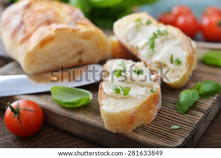 Bread with cheese cherry tomato and a basil leaves on wooden cutting board closeup