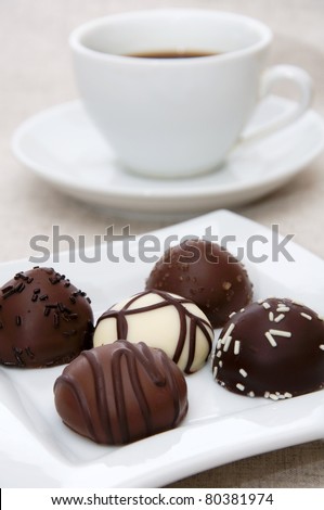 Some chocolate candies with different flavors on white plate