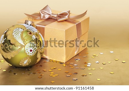 Golden gift box with christmas decoration over gold background