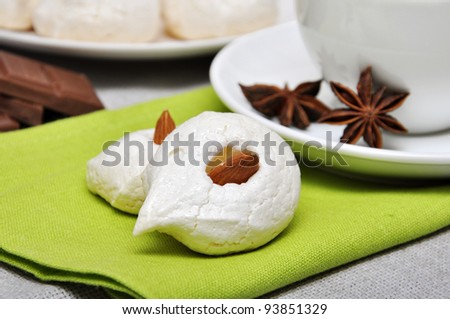 Homemade meringues with almond and cup of tea, shallow dof. Focused on meringues.