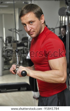 health club: man in a gym doing weight lifting