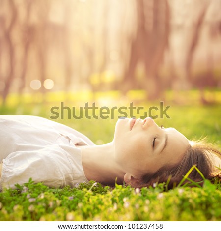 beautiful girl relaxing lying on the grass in the garden