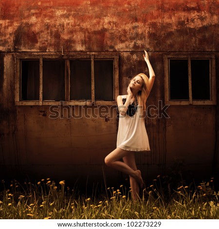 pretty girl posing against a background of metal construction