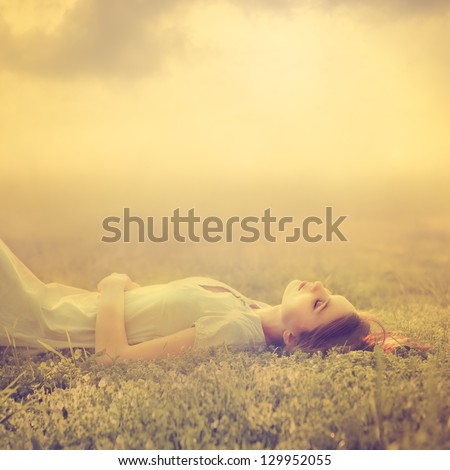 beautiful young girl dreams of lying on a magic meadow in spring