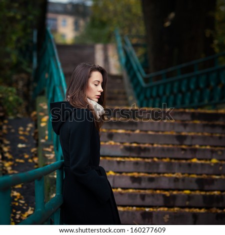 sad lonely girl stands in autumn city
