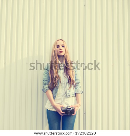 Vintage portrait of a beautiful girl with a camera