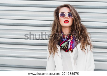sexy girl with red lips on a background of a fence on a sunny day