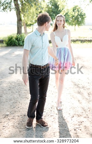 beautiful young couple in love young people walking in the park